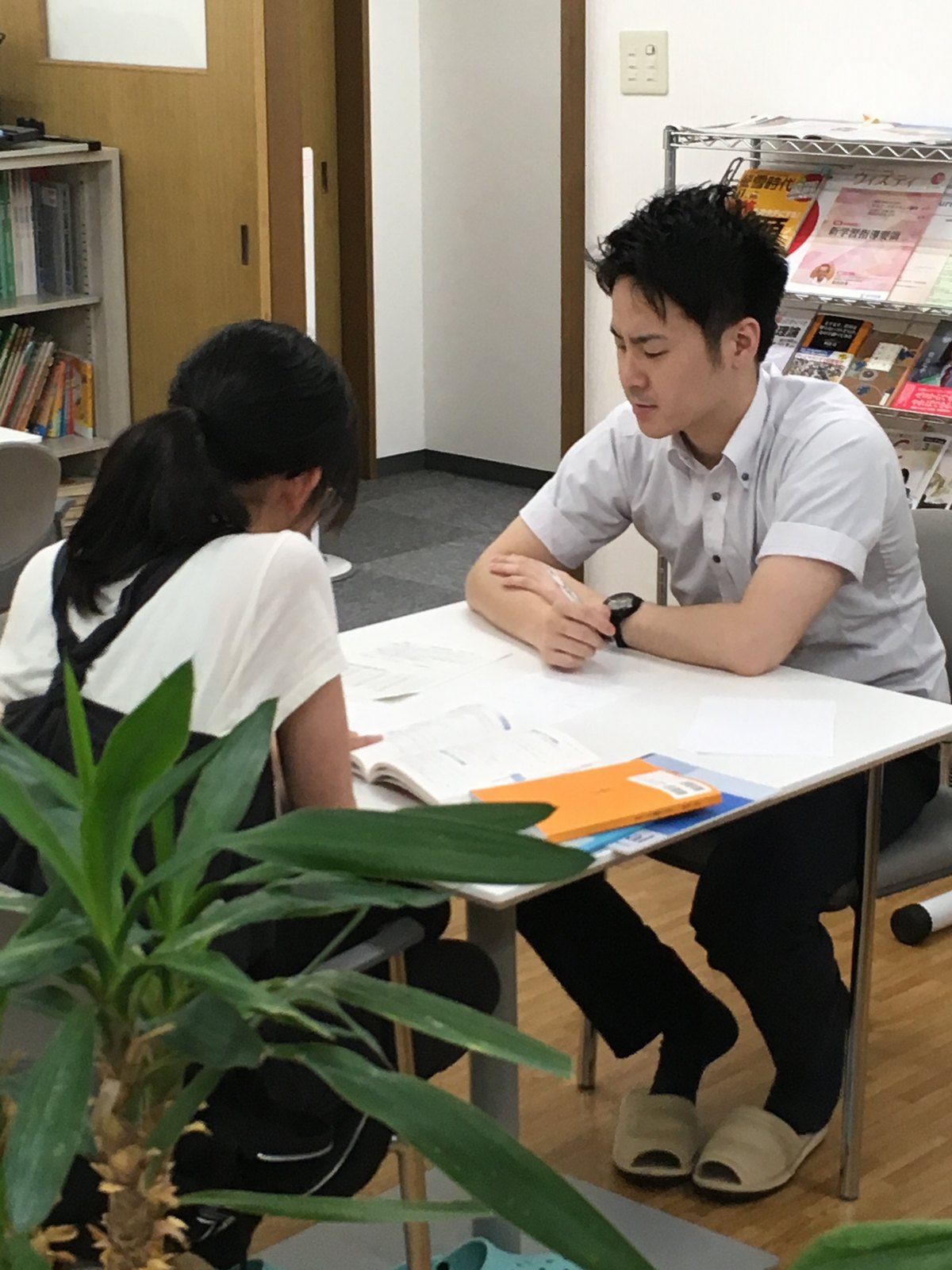 講師と生徒が机をはさんで話している面談